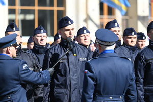 komendant wojewódzki stoi tyłem przed nim kompania policjantów którzy będą składać ślubowanie obok policjant który trzyma mikrofon