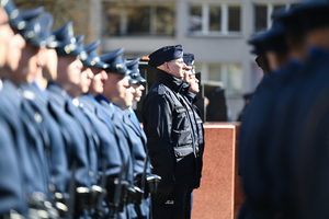 na pierwszym planie mniej wyraźni policjanci z kompanii honorowej obok niech ostrość ustawiona na kilku policjantów oddających honor