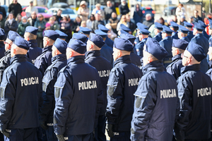 zdjęcie policjantów składających mianowanie stoją tyłem w tle mnie widoczni zaproszeni goście