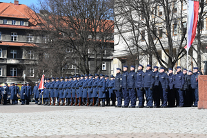 na zdjęciu widoczna większość placu z uroczystościami widoczna kompania honorowa oraz kompani z policjantami składającymi ślubowanie po lewej stronie zaproszeni goście oraz rodziny policjantów