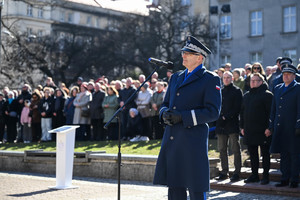 zdjęcie komendanta wojewódzkiego policji w Katowicach podczas przemówienia w tle za nim rodziny policjantów zaproszeni goście oraz komendanci miejscy i powiatowi