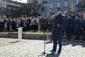 zdjęcie komendanta wojewódzkiego policji podczas przemówienia za nim komendanci miejscy i powiatowi oraz zaproszeni goście oraz rodziny policjantów składających ślubowanie