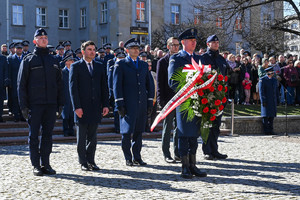 delegacja składająca wieniec pod pomnikiem w której są policjanci komendant wojewódzki oraz wojewoda