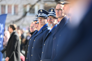 zbliżenie na komendanta wojewódzkiego obok niego stoją mniej widoczni zaproszeni goście oraz wojewoda