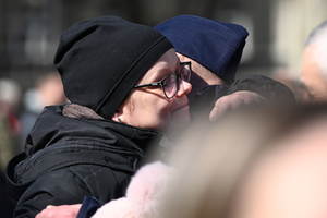 zdjęcie policjanta którego przytula oraz składa gratulacje najbliższa rodzina