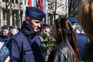 zbliżenie na policjanta któremu gratulują bliscy