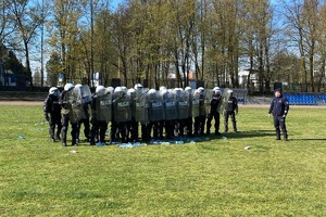 Zdjęcie przedstawia grupę policjantów podczas szkolenia w szyku.
