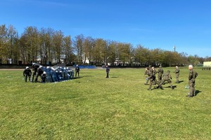 Zdjęcie przedstawia grupę policjantów oraz żołnierzy wykonujących ćwiczenia podczas szkolenia.