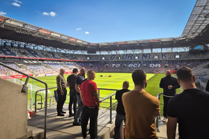 Zdjęcie przedstawia grupę mężczyzn na terenie stadionu piłki nożnej.