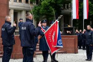 Na zdjęciu policjant trzymający sztandar Komendy Miejskiej Policji w Katowicach oraz dwóch policjantów i policjantka w momencie ślubowania.