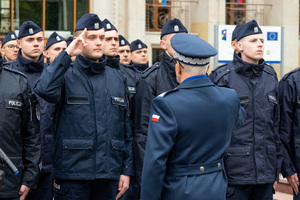 Zdjęcie przedstawia policjanta oddającego honor stojącemu przed nim Komendantowi Wojewódzkiemu Policji w Katowicach.
