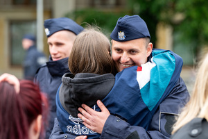 Na zdjęciu policjant przytulający kobietę