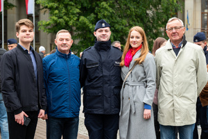 Na zdjęciu policjant stojący w rzędzie z trzema mężczyznami i kobietą