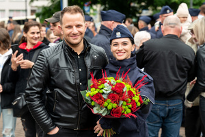 Na zdjęciu policjantka z kwiatami w towarzystwie mężczyzny