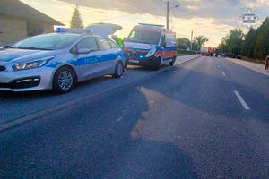 Miejsce wypadku drogowego - na pierwszym planie  radiowóz i karetka pogotowia