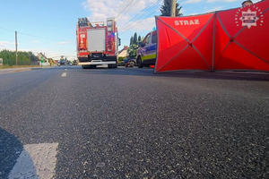 Miejsce wypadku drogowego - na pierwszym planie  parawan i wóz strażacki