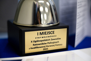 na zdjęciu fragment pucharu, na którym widoczna tabliczka z napisem pierwsze miejsce etap wojewódzki dziesiątych ogólnopolskich zawodów ratowników policyjnych z kwalifikowanej pierwszej pomocy