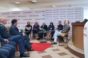 na zdjęciu osoby na widowni, obok prelegenci sympozjum