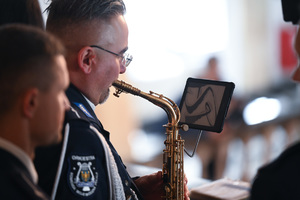 Zdjęcie przedstawia policjanta grającego na instrumencie