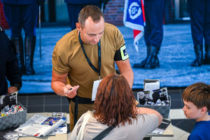Zdjęcie przedstawia grupę osób oraz Strażaka PSP