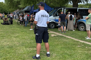 Zdjęcie przedstawia policjanta stojącego tyłem