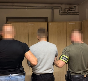 policjanci prowadzą zatrzymanego