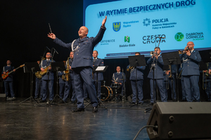 Zdjęcie przedstawia orkiestrę wraz z dyrygentem
