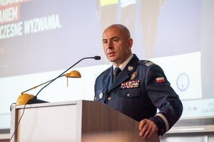Zdjęcie przedstawia nadinspektora doktora Rafała Kochańczyka podczas przemowy na konferencji.