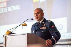 Zdjęcie przedstawia nadinspektora doktora Rafała Kochańczyka podczas przemowy na konferencji.