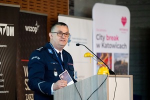 Zdjęcie przedstawia Policjanta w umundurowaniu przemawiającego podczas seminarium.