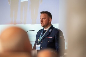 Zdjęcie przedstawia inspektora Radosława Kacprzaka przemawiającego podczas konferencji.