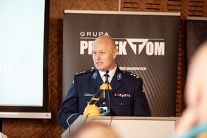 Zdjęcie przedstawia przemawiającego przy pulpicie młodszego inspektora Tomasza Stechnij.