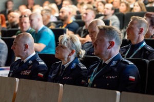 Zdjęcie przedstawia uczestników Konferencji siedzących w Auli AWF Katowice, wśród których są umundurowani policjanci.