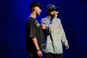 Zdjęcie przedstawia: dwóch muzyków na scenie.