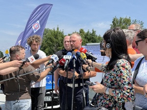 zdjęcie prezentuje oficerów policji oraz dziennikarzy w trakcie konferencji prasowej