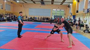 Zdjęcie przedstawia zawodników rywalizujących na macie w Brazylijskim Ju-Jitsu