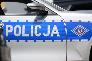 Zdjęcie przedstawia drzwi oznakowanego radiowozu policji.