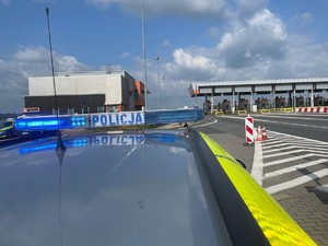 zdjęcie radiowozu policyjnego na tle autostradowych bramek