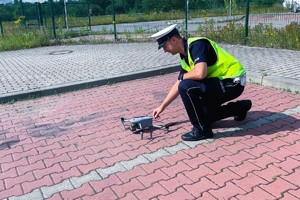 funkcjonariusz ruchu drogowego uruchamiający urządzenie typu dron