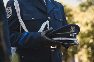 zdjęcie przedstawia funkcjonariusza kompani honorowej, który trzyma czapkę podoficera policji