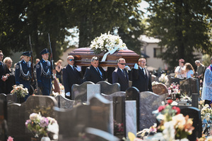 zdjęcie przedstawia ceremonię pogrzebową na cmentarzu