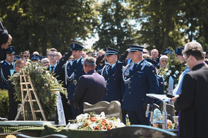 oficerowie policji oddający honory na cmentarzu