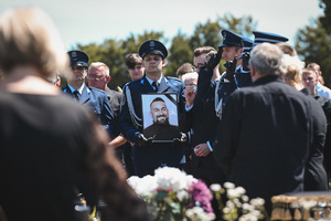 zdjęcie przedstawia funkcjonariuszy asysty honorowej, którzy trzymają zdjęcie pod. kom. Dariusza Stypuły