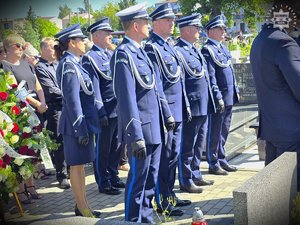 zdjęcie przedstawia oficerów policji podczas ceremonii pogrzebowej na cmeantarzu