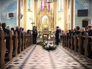 zdjęcie przedstawia wnętrze kościoła wraz z trumną, funkcjonariuszami asysty honorowej oraz zgromadzonymi gośćmi.