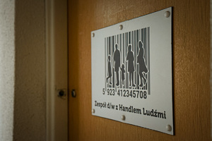 zdjęcie przedstawia drzwi jednostki policji na których widnieje napis Zespół d/w z Handlem Ludźmi