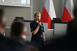 Zdjęcie przedstawia policjantkę z mikrofonem podczas doskonalenia zawodowego