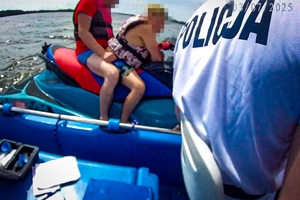 Zdjęcie przedstawia policjantów Oddziału Policji Prewencji w Katowicach podczas interwencji wobec nietrzeźwego kierującego skuterem wodnym na Jeziorze Łąka w Pszczynie.