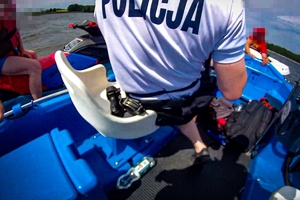 Zdjęcie przedstawia policjantów Oddziału Policji Prewencji w Katowicach podczas interwencji wobec nietrzeźwego kierującego skuterem wodnym na Jeziorze Łąka w Pszczynie.