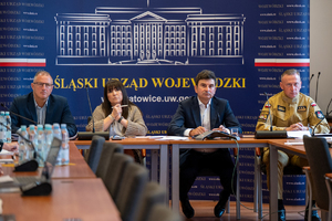 na zdjęciu wojewoda śląski, strażak i inne osoby przy stole